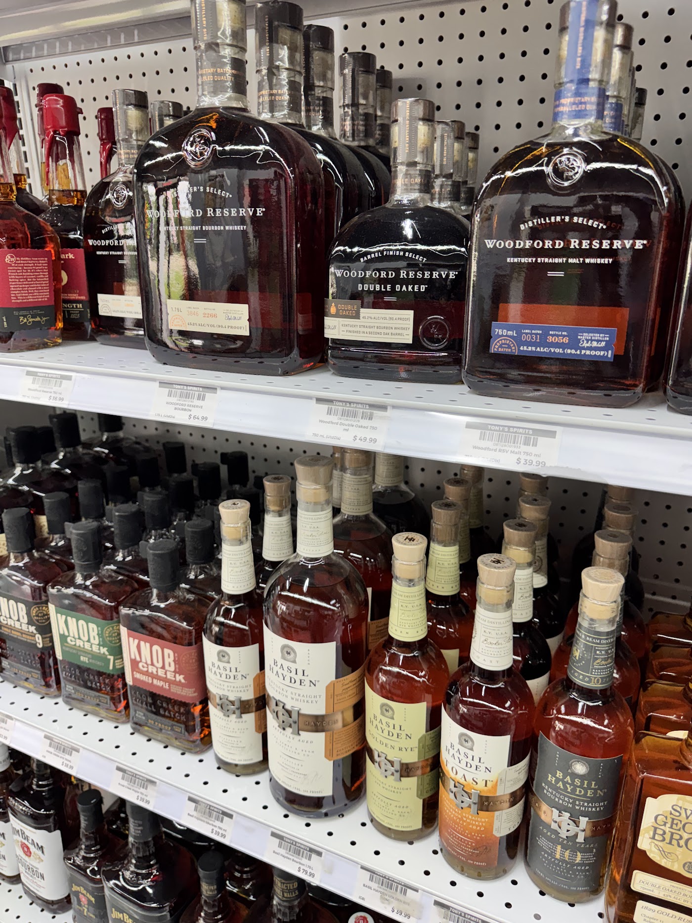Bourbon and whiskey shelf stocked with Woodford Reserve